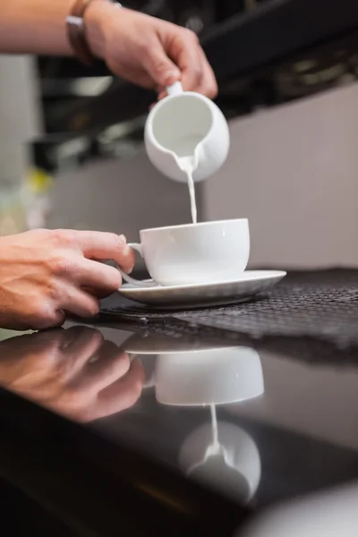 Barista gießt Milch in Tasse Kaffee — Stockfoto