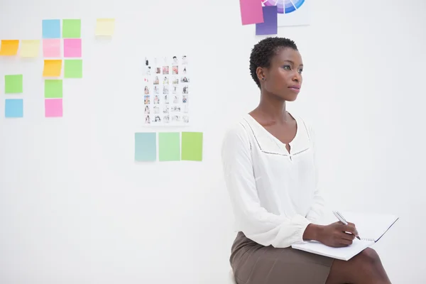 Thoughtful designer writing on notebook — Stock Photo, Image