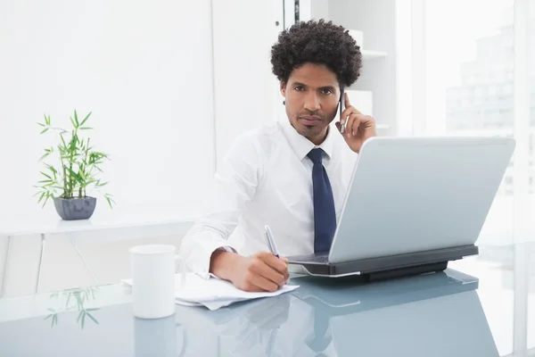 Empresário em camisa telefonando e tomando notas — Fotografia de Stock