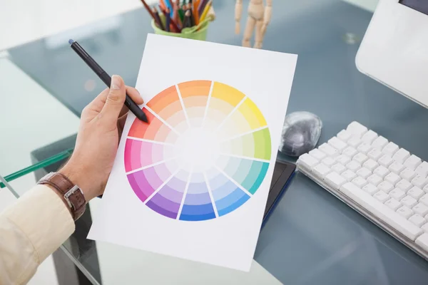 Дизайнер, що працює за столом, використовуючи кольорове колесо — стокове фото