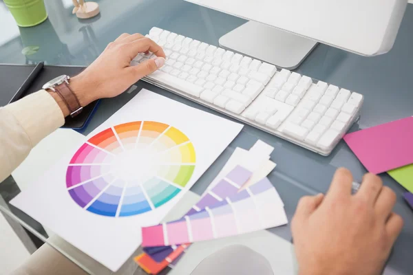 Designer usando computador e roda de cores — Fotografia de Stock