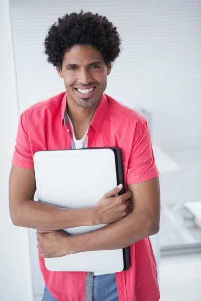 Sorridente uomo d'affari casuale che tiene il computer portatile — Foto Stock