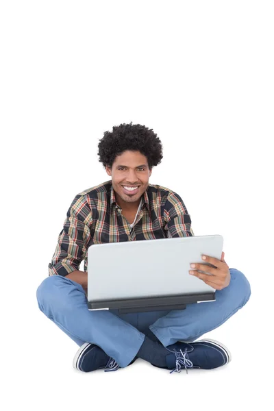 Sorrindo homem sentado e usando laptop — Fotografia de Stock