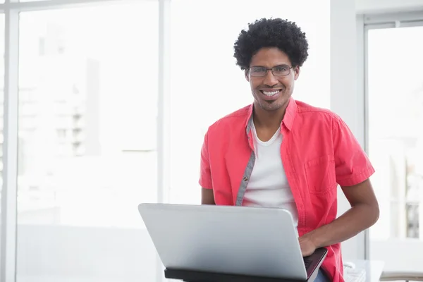 Casual businessman smiling and using laptop — Stock Photo, Image