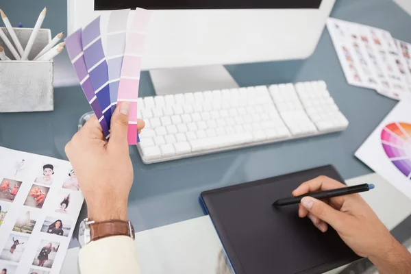 Desainer yang bekerja di meja menggunakan digitizer dan sampel warna — Stok Foto