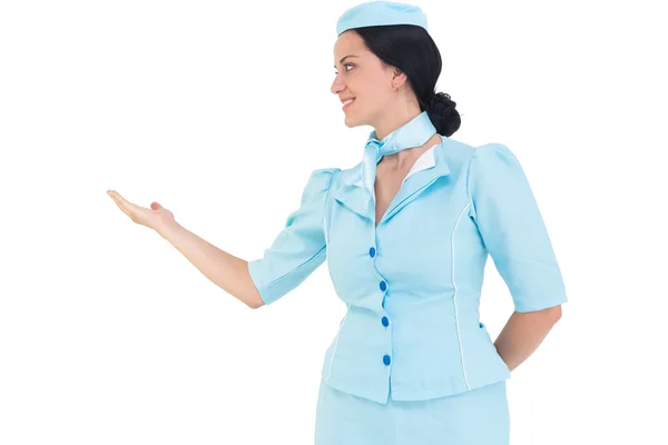 Pretty air hostess presenting with hand — Stock Photo, Image