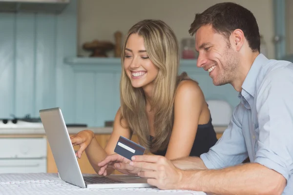 Casal bonito usando laptop juntos para comprar on-line — Fotografia de Stock