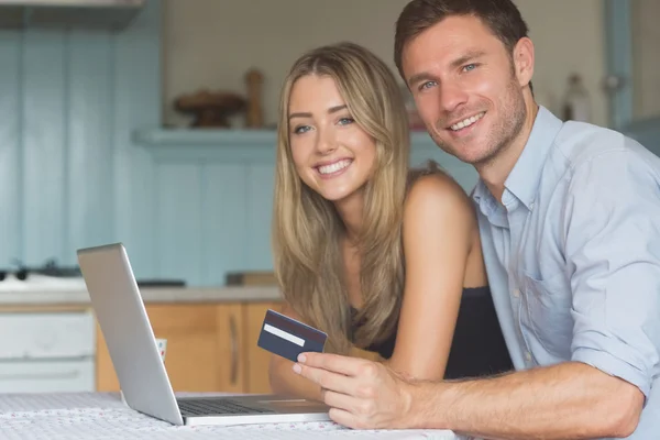 Couple mignon en utilisant un ordinateur portable ensemble pour faire des achats en ligne — Photo