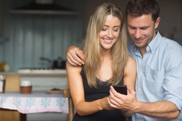 Cute couple using smartphone together — Stock Photo, Image