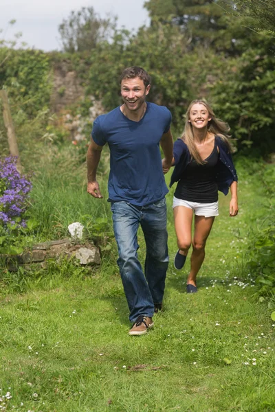 Linda pareja corriendo cogidas de la mano — Foto de Stock