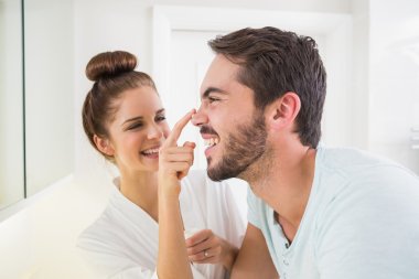 Young woman touching her boyfriends nose clipart