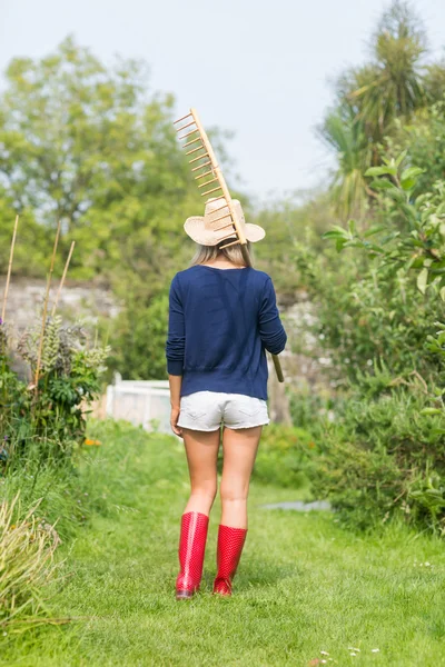 Jardinería rubia sosteniendo un rastrillo —  Fotos de Stock