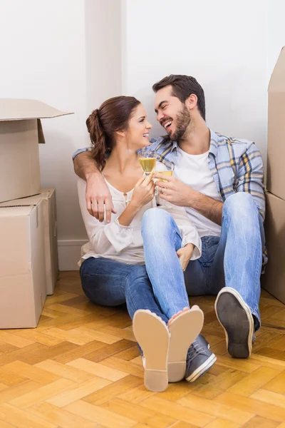 かわいいカップルを床にシャンパンで乾杯 — ストック写真