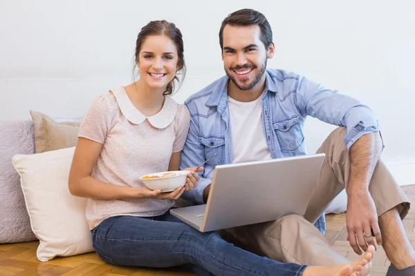 Leuk paar zittend op de vloer met behulp van laptop — Stockfoto