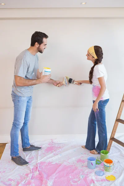 Bonito casal pintando a parede — Fotografia de Stock