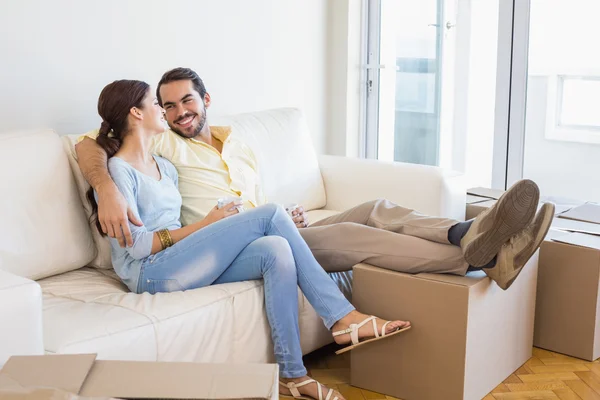 Pareja joven tomando un descanso de desempacar — Foto de Stock