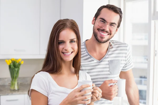 Jeune couple souriant à la caméra prenant un café — Photo