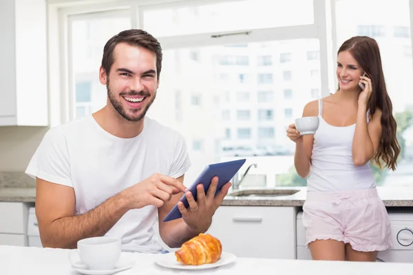 Jovem usando tablet pc no café da manhã — Fotografia de Stock