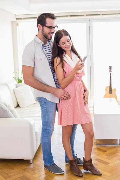 Hipster brunette using her smartphone with boyfriend — Stock Photo, Image