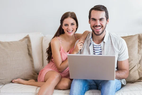 流行に敏感なカップルがソファでノート パソコンを使用して — ストック写真