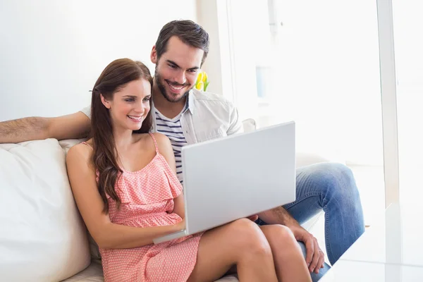 Couple Hipster en utilisant un ordinateur portable sur le canapé — Photo