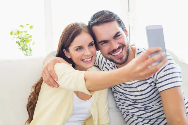 Aranyos pár vesz egy selfie, kanapéra — Stock Fotó