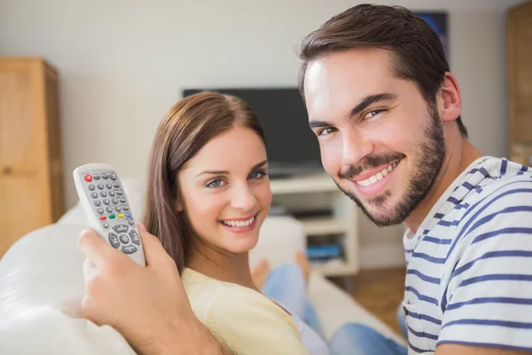 Cute couple watching tv on the couch — Stock Photo, Image