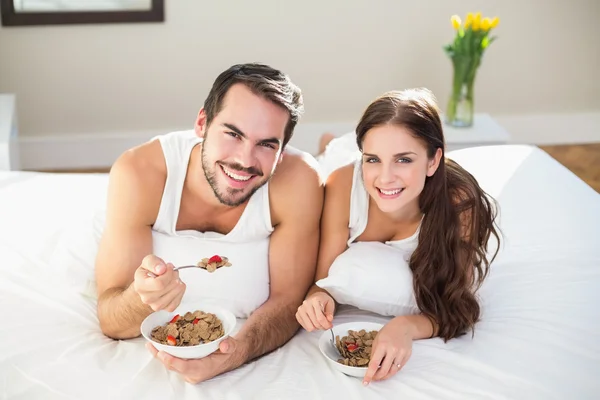 Jeune couple prenant le petit déjeuner au lit — Photo