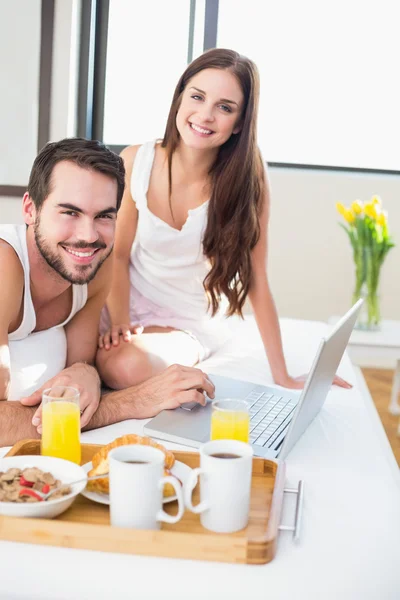 Unga par äter frukost på sängen — Stockfoto