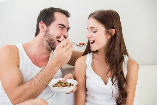 Unga par äter frukost på sängen — Stockfoto