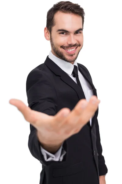 Lachende zakenman met zijn hand uit — Stockfoto