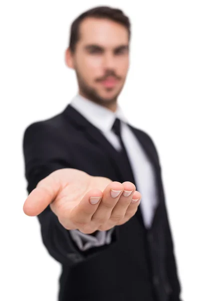 Cheerful businessman offering with his open hand — Stock Photo, Image