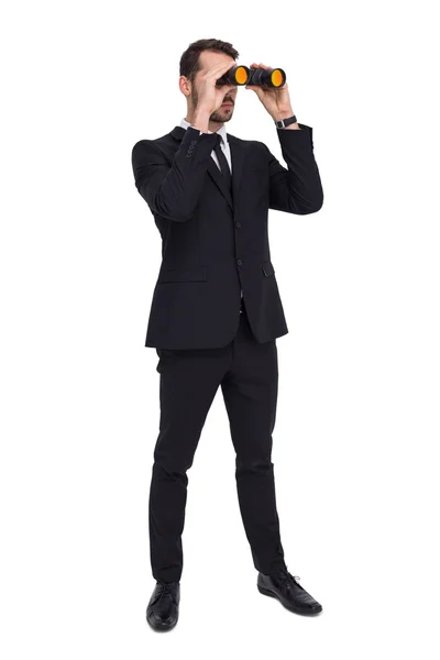 Elegant businessman standing and using binoculars — Stock Photo, Image