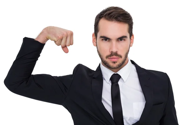 Businessman tensing arm muscle and looking at camera — Stock Photo, Image