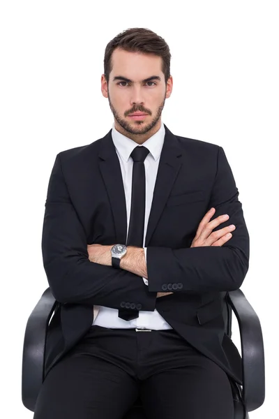 Serious businessman sitting with arms crossed — Stock Photo, Image