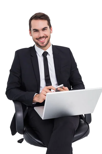 Hombre de negocios feliz con el ordenador portátil usando smartphone — Foto de Stock
