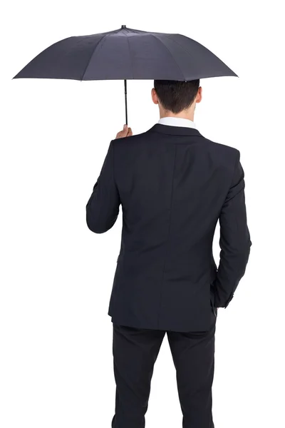 Вид сзади на укрытие бизнесмена зонтиком — стоковое фото
