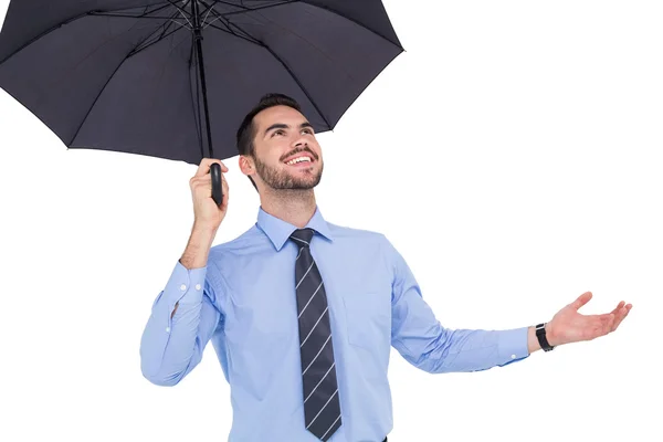 Empresário feliz abrigando com um guarda-chuva preto — Fotografia de Stock