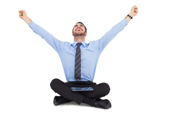 Businessman cheering with tablet sitting on floor — Stock Photo, Image