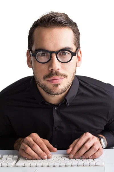 Hombre de negocios sonriente con gafas escribiendo en el teclado — Foto de Stock