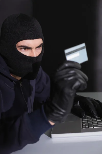 Hacker in balaclava spending money online — Stock Photo, Image