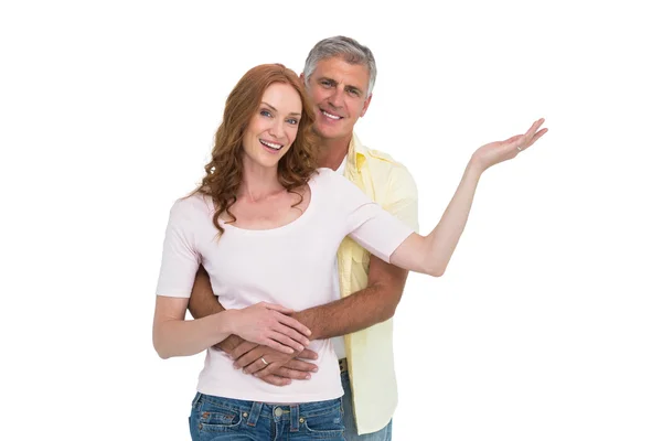 Casual couple smiling and presenting — Stock Photo, Image