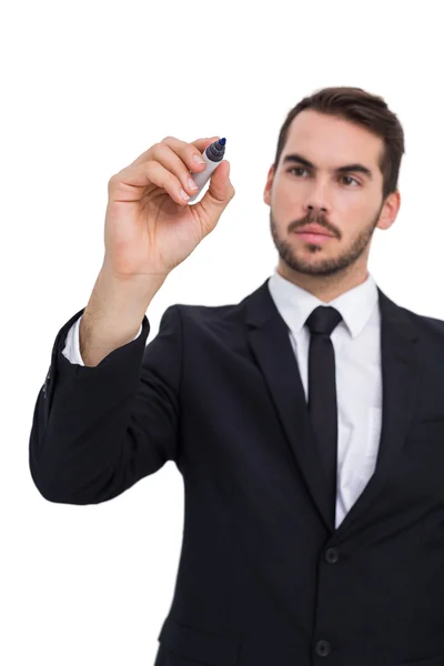 Thoughtful businessman writing with marker Stock Photo