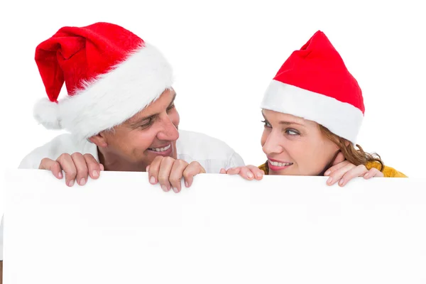 Casal festivo mostrando um cartaz — Fotografia de Stock