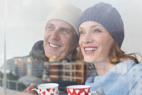 Couple heureux en vêtements chauds tenant des tasses — Photo