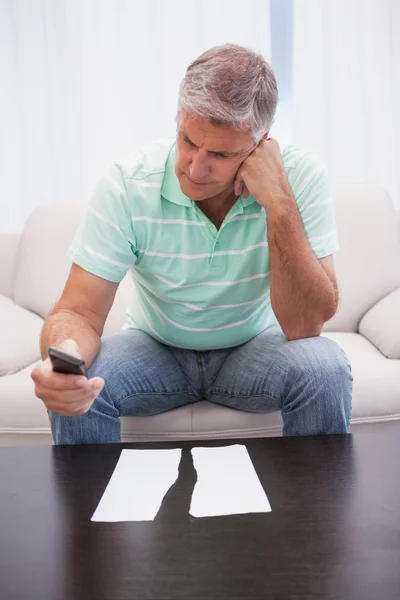 Worried man looking at ripped page sending a text — Stock Photo, Image