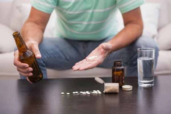 Man mixing beer with his medicine — Stock Photo, Image