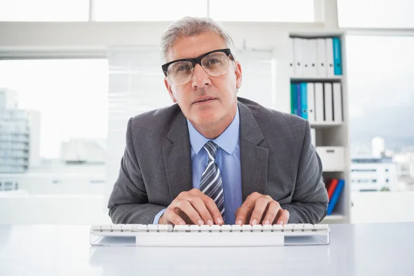 Hombre de negocios enfocado escribiendo en su escritorio — Foto de Stock