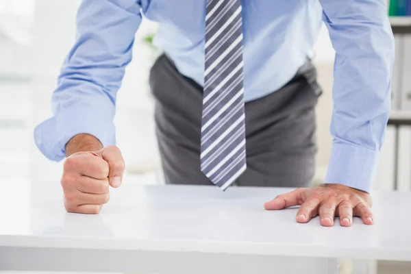 Businessmans fist clenched over desk — Stock Photo, Image