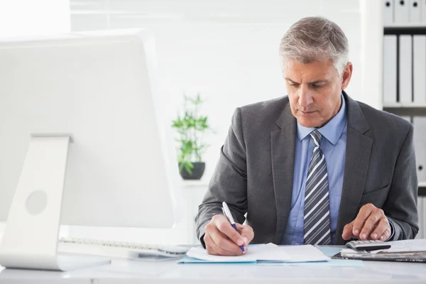 Un homme d'affaires concentré écrit quelque chose — Photo